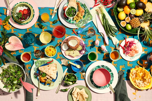 Vrolijk gedekte tafel in warme kleuren in Mexicaanse stijl met dips en burritos