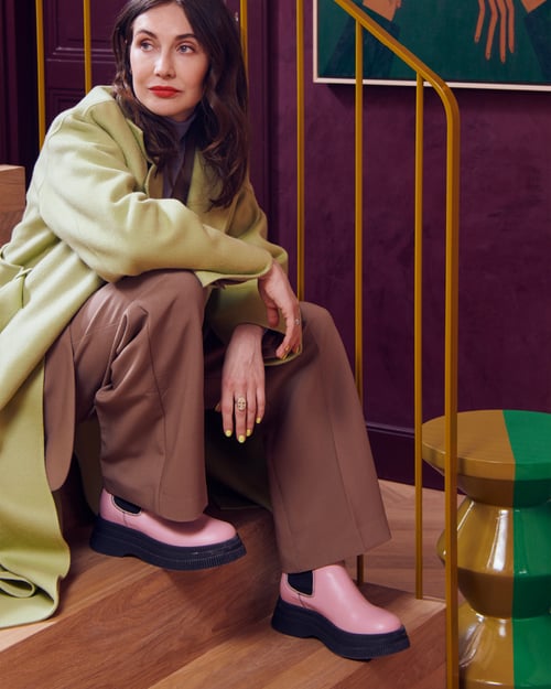 Carice van Houten op een stijlvolle trap in een kleurrijk interieur