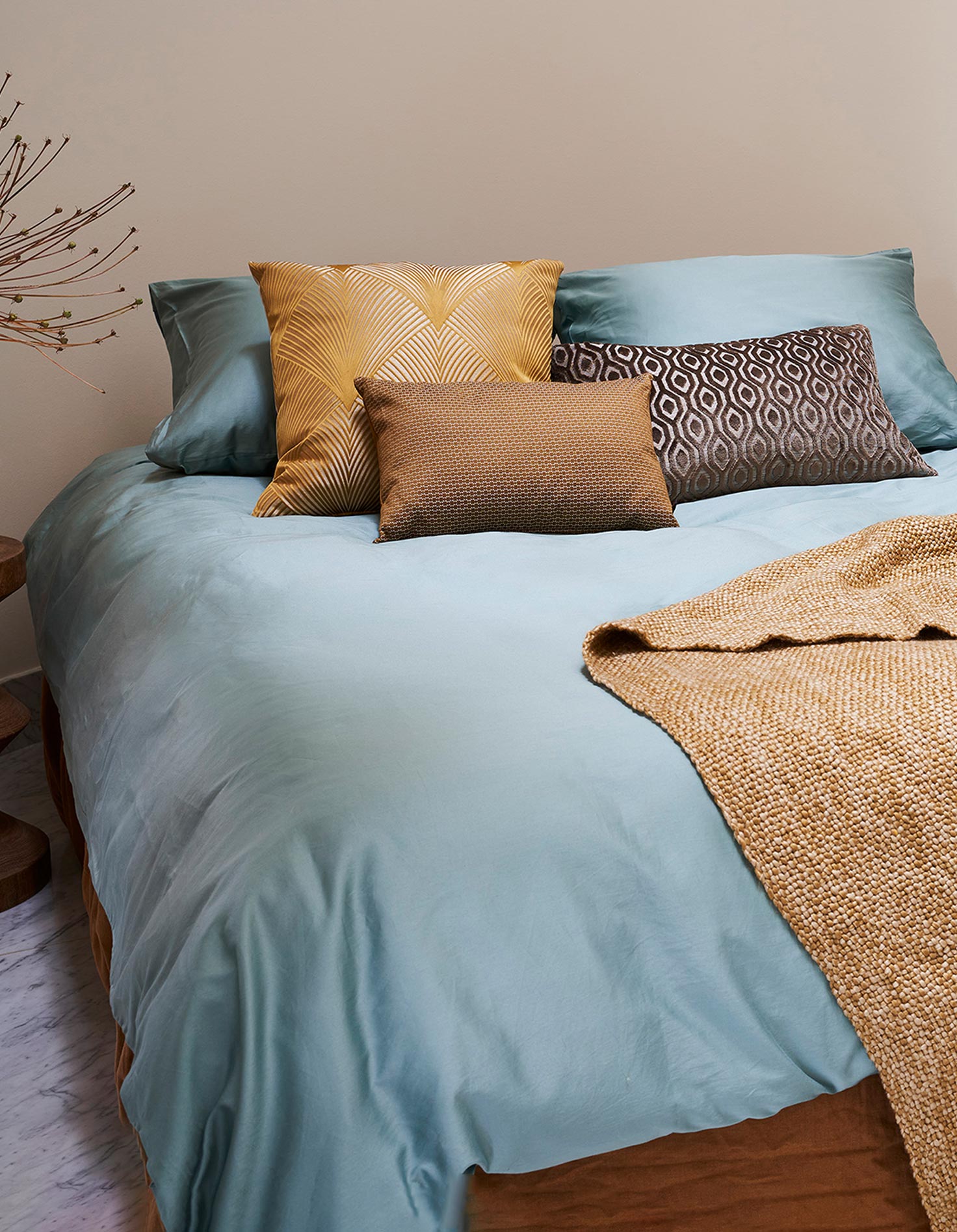 Boutique hotel slaapkamer met licht blauw beddengoed van Essenza sierkussens en een donkergele sprei