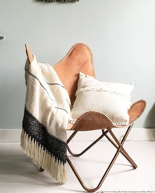 Stoel gedrapeerd met warm plaid van HAY